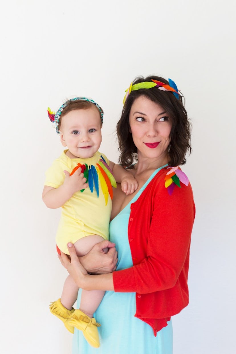 Mom and baby wearing brightly colored clothes with colorful feathers 