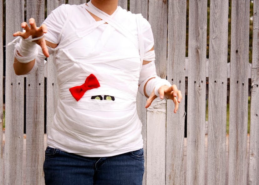 Pregnant woman in costume that looks like the bump is a mummy