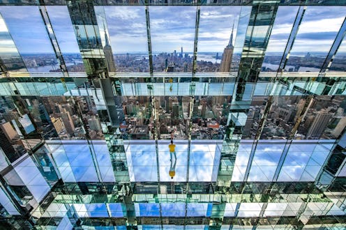 Glass, reflective, mirrored room overlooking the NYC cityscape.