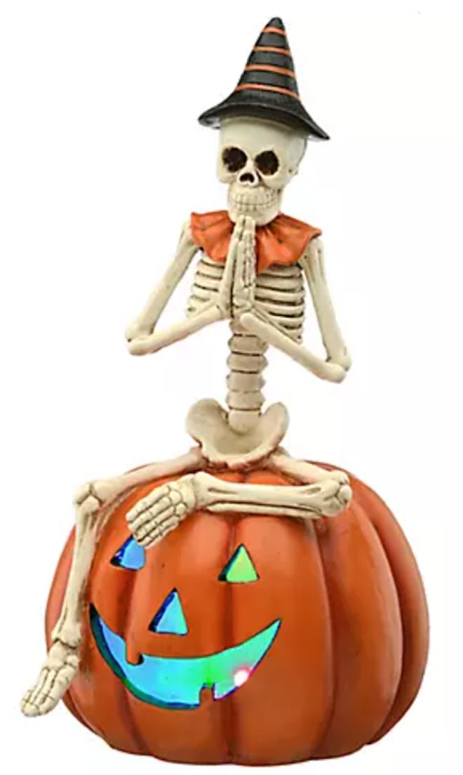 This Halloween tabletop decor from BJ's features a skeleton sitting on a pumpkin.