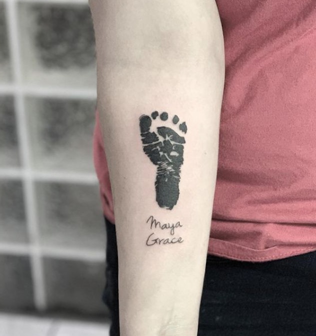 Footprint of a baby tattoo with the child's name below