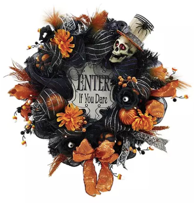 A wreath decorated for Halloween in skulls and leaves