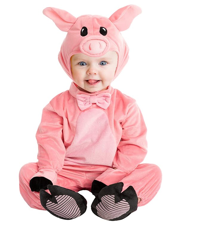 Baby sitting up in a pig costume