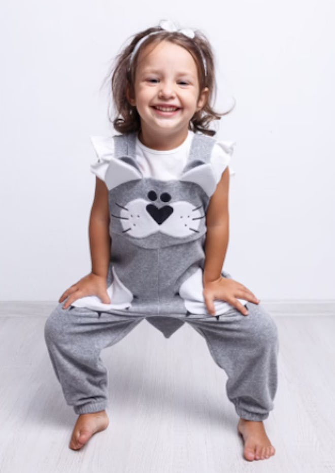 Child wearing a pair of cat overalls