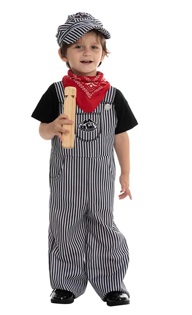 Toddler in overalls, hat, and scarf to look like a train conductor