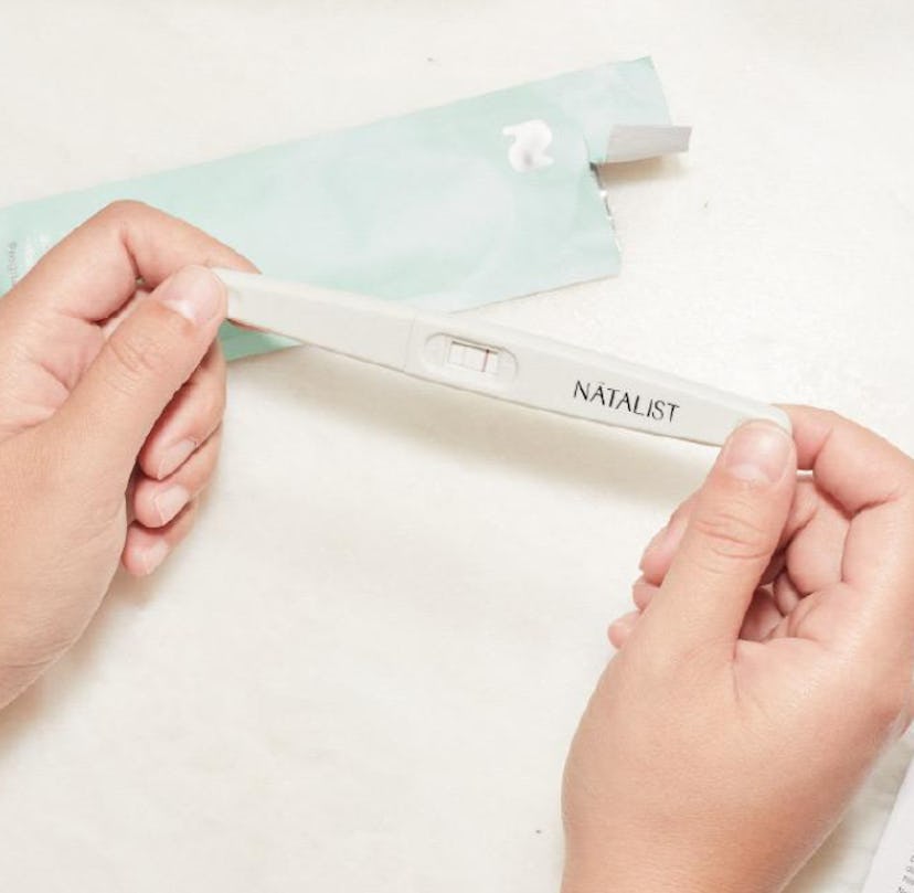 Hands holding a positive pregnancy test