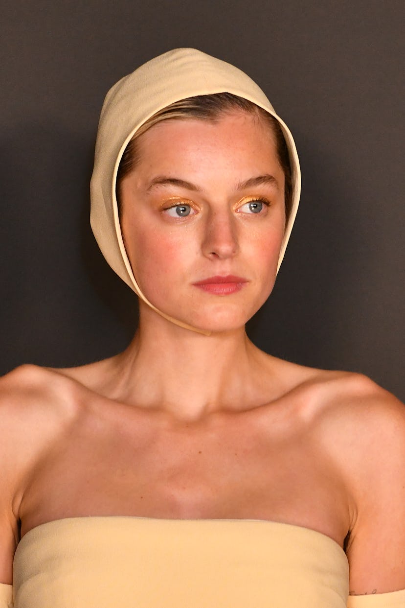 Emma-Louise Corrin in a beige dress and hat at the Emmys 2021