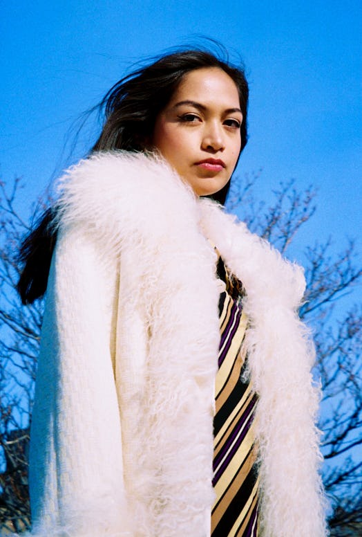 Marlowe Granados in a white fur coat over a striped multicolored shirt