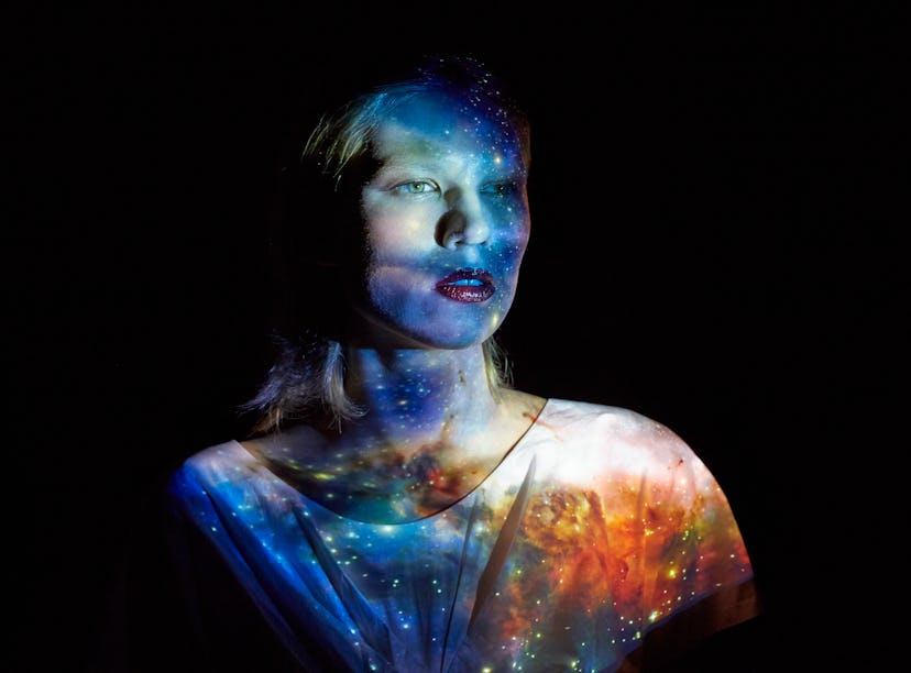 Young woman with the universe projected on to her to show the Grand Cross in astrology.