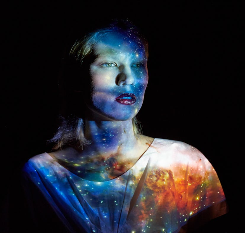 Young woman with the universe projected on to her to show the Grand Cross in astrology.
