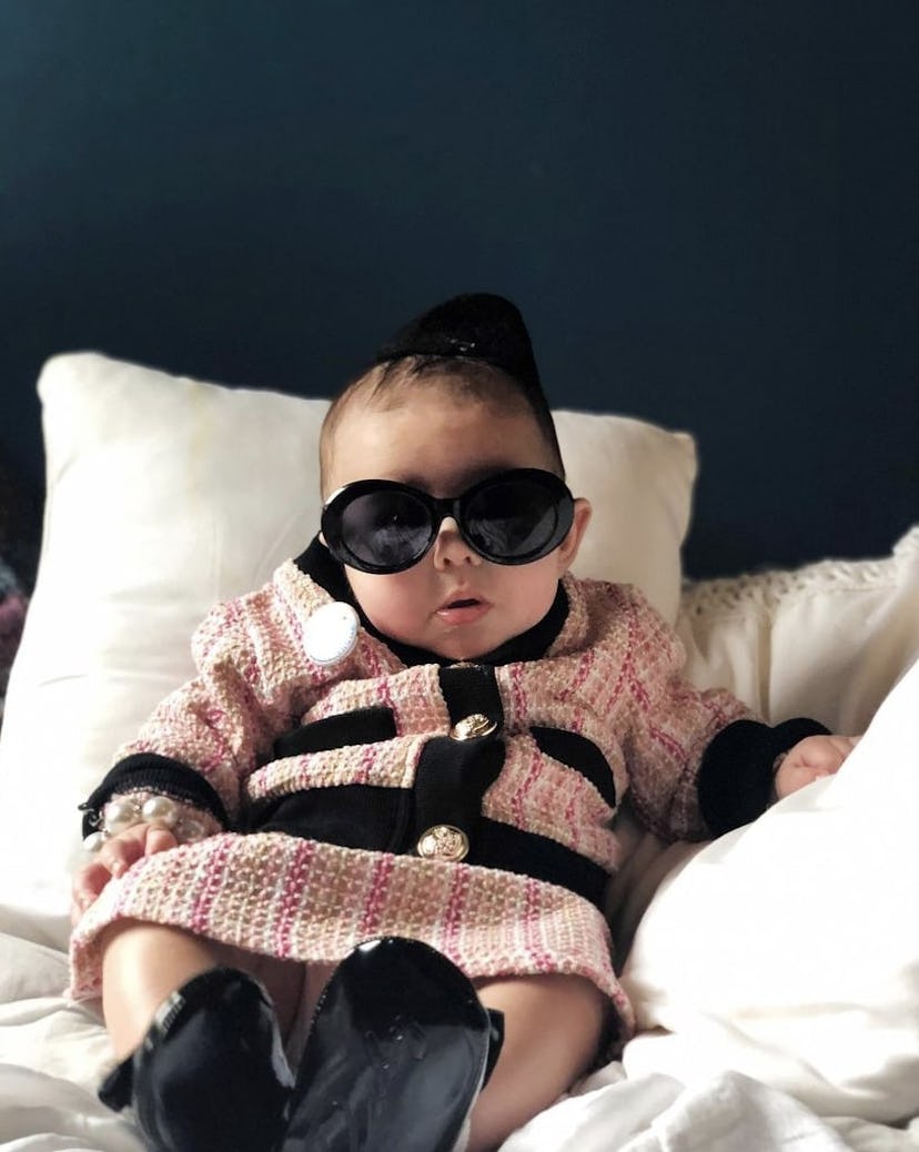 baby dressed as Jackie Onassis Kennedy for Halloween in pink plaid suit and black sunglasses