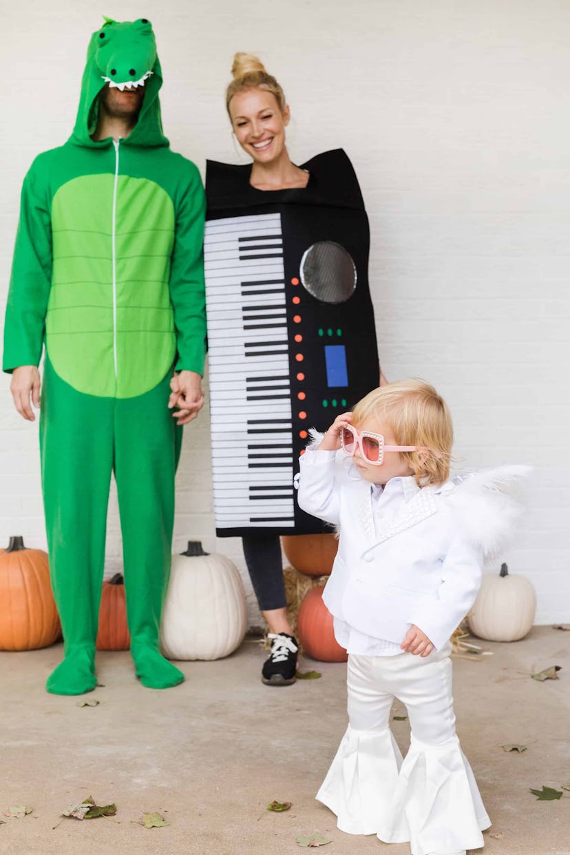 Man dressed a crocodile, woman as a keyboard, baby as Elton John