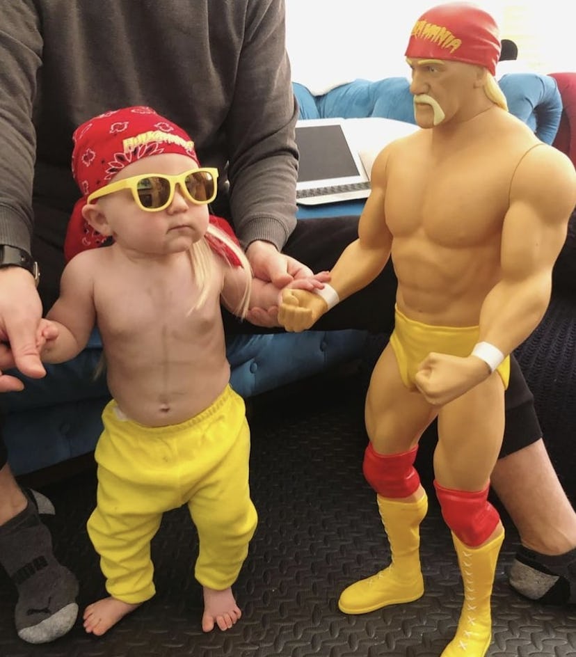 baby dresses as wrestler Hulk Hogan in yellow pants, yellow sunglasses, red bandana, standing next t...