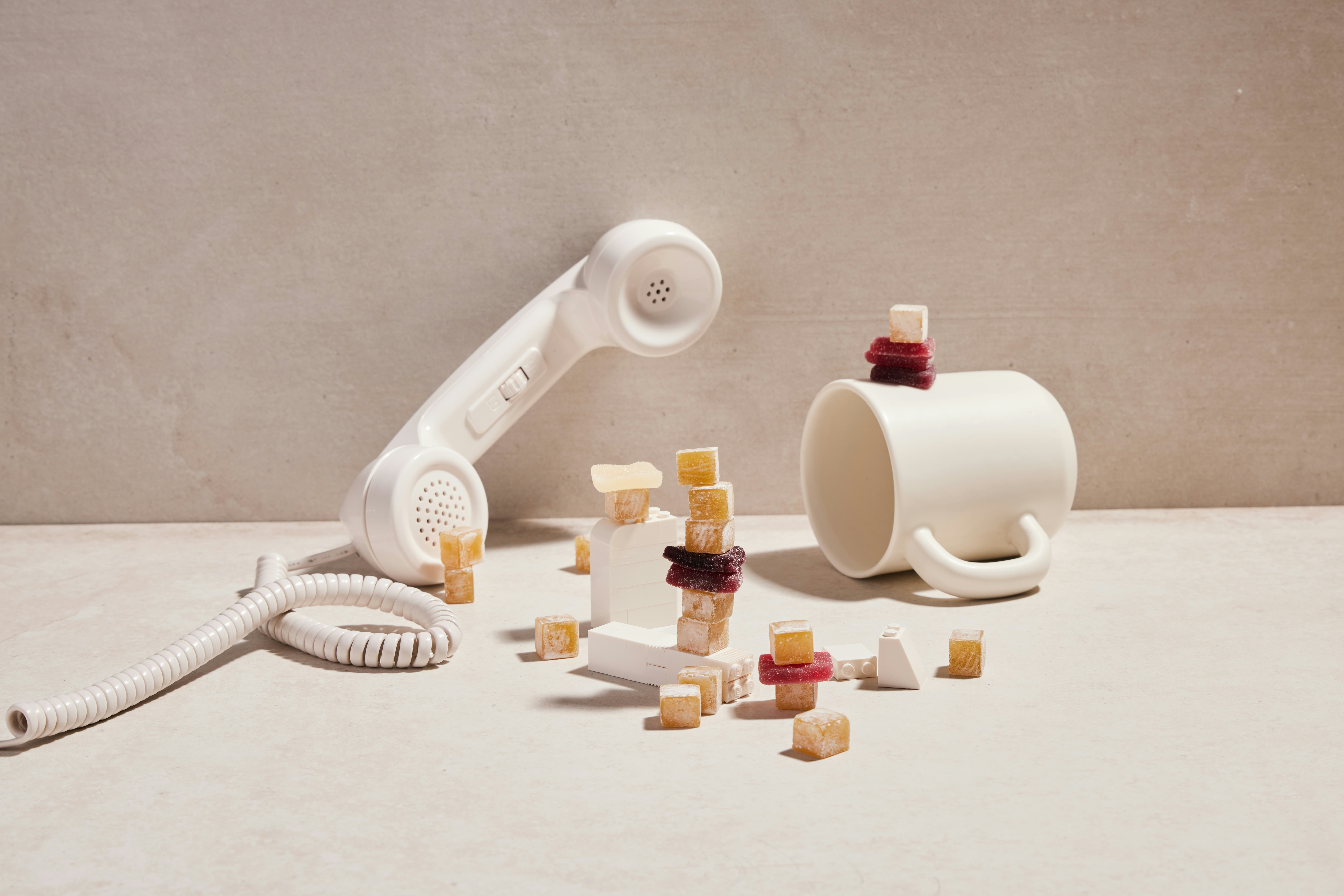 artfully arranged CBD gummies, with a phone, a cup, and white legos 