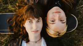 2 friends laying in the grass discussing Libra-Pisces friendship compatibility.
