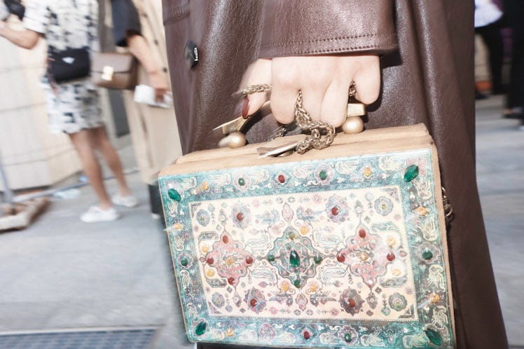 A close-up of a book-shaped bag being held by someone at Milan Fashion Week 2022
