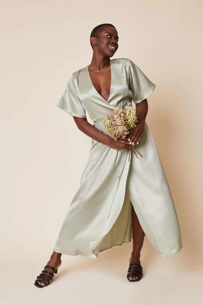 model wearing a silk-like wrap dress in light sage from sustainable brand whimsy + row