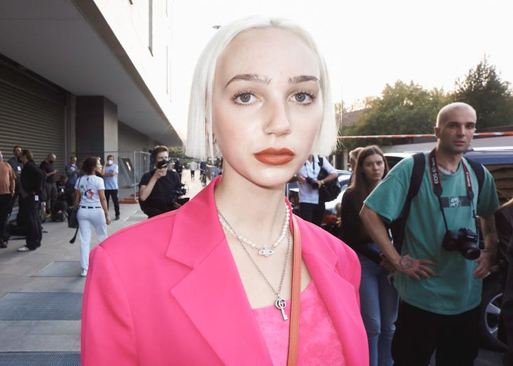 A close-up portrait of a person in a pink top and a pink blazer at Milan Fashion Week 2022