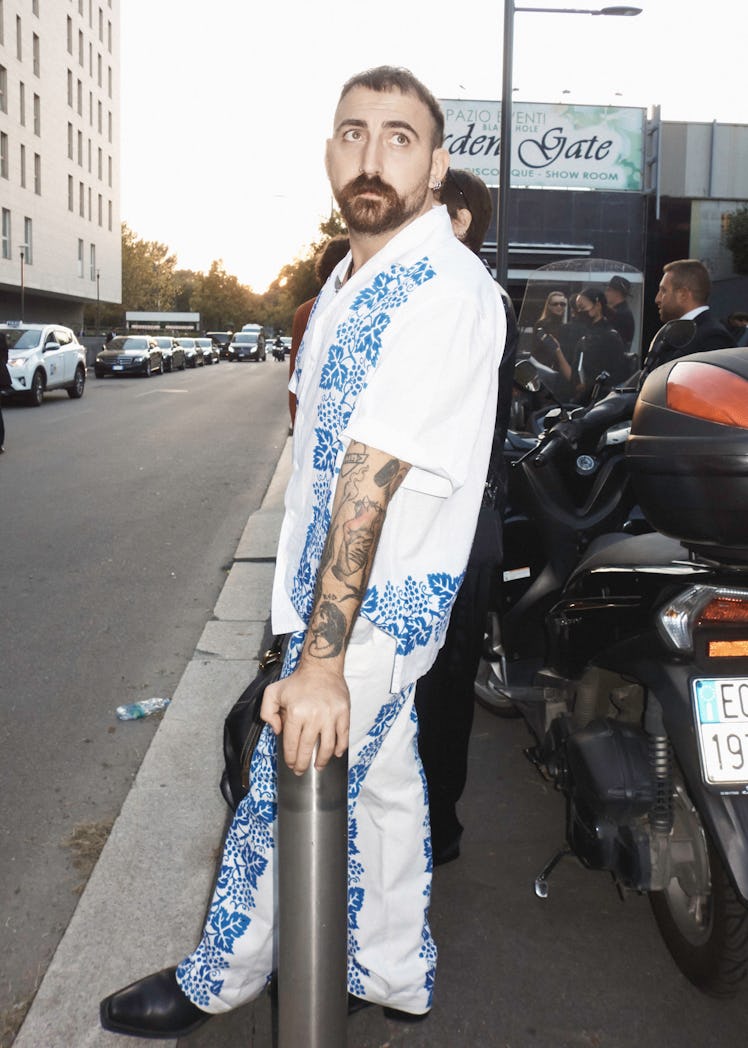 A man in a white and blue floral shirt and trousers at Milan Fashion Week 2022