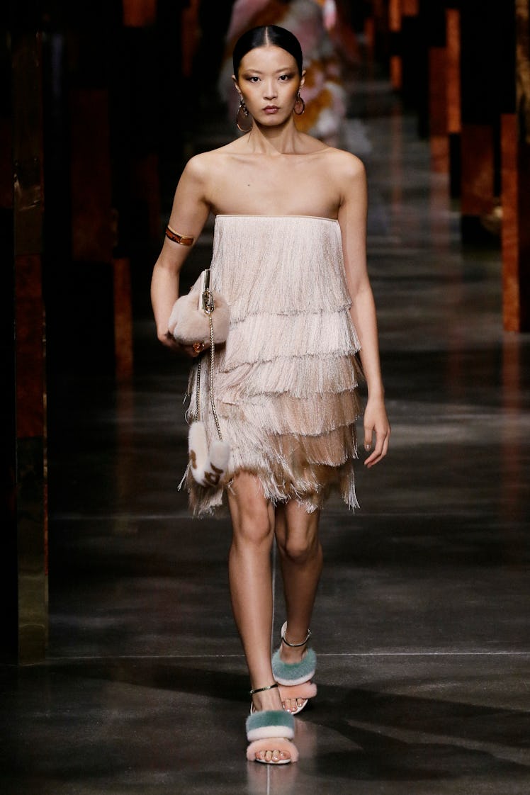A model walking the runway at Milan Fashion week in a Fendi beige fringe dress 