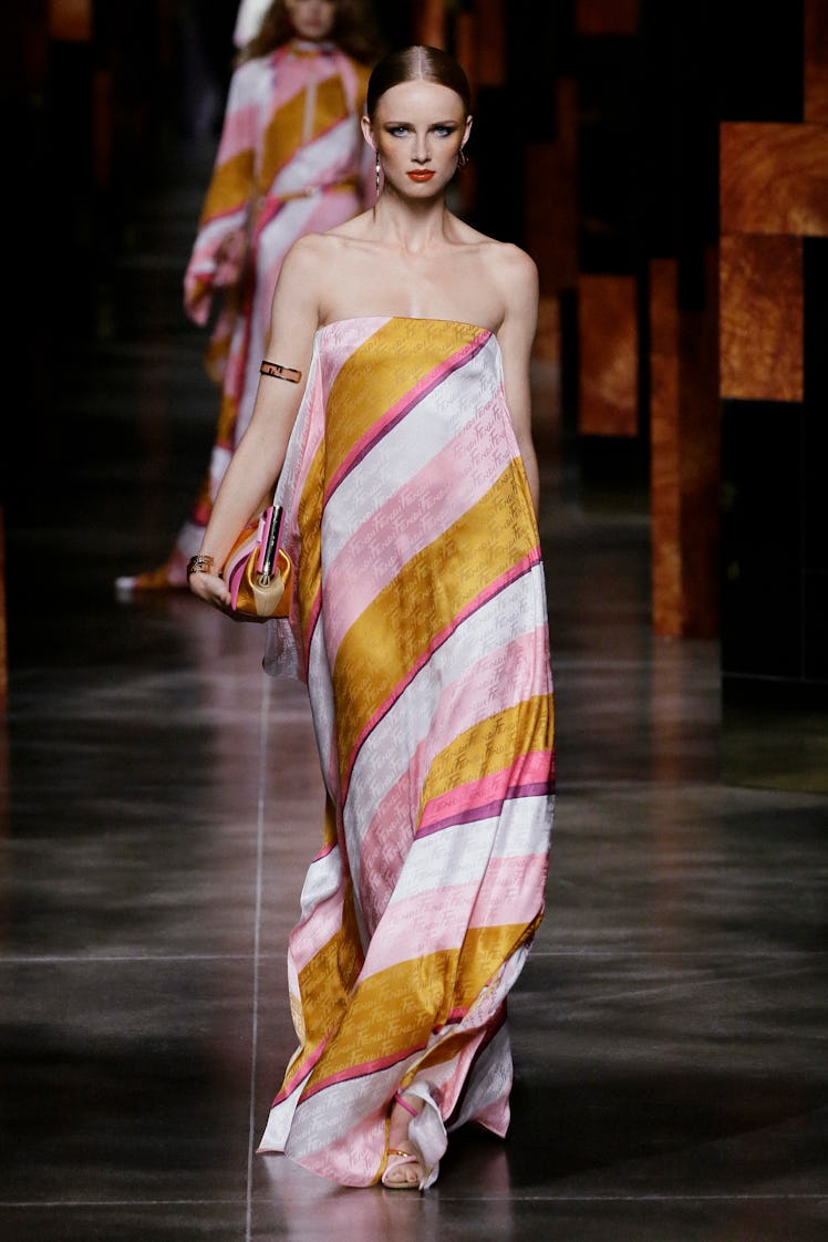 A model walking the runway at Milan Fashion week in a Fendi silk dress with diagonal stripes 