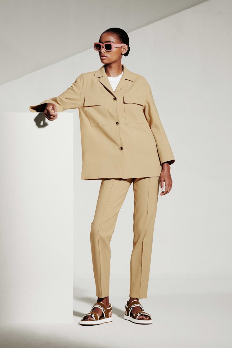 A model in a beige suit and sandals by Loro Piana 