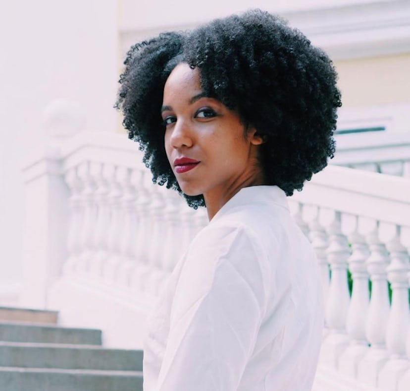 A photo of the author in a white suit with her natural curls on display. Here's how she navigates he...