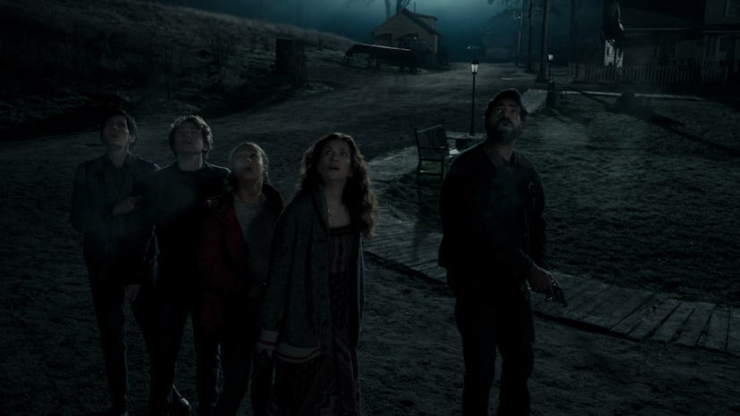 Five members of MIDNIGHT MASS stand huddled on a dark street all looking up at something off-camera.