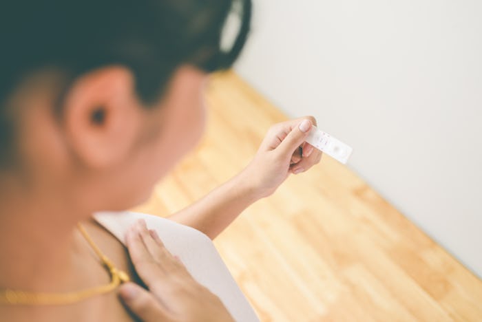 can you get pregnant with just a little sperm? woman looking at pregnancy test result