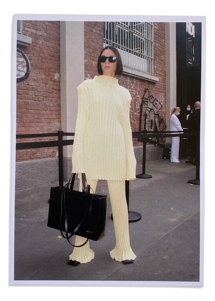 A woman in an yellow knit matching sweater and pants at Milan Fashion Week 2022