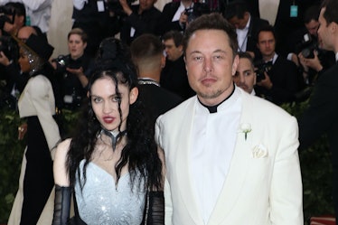Elon Musk in a white shirt and cream suit and Grimes in a white-black sequin dress and black gloves