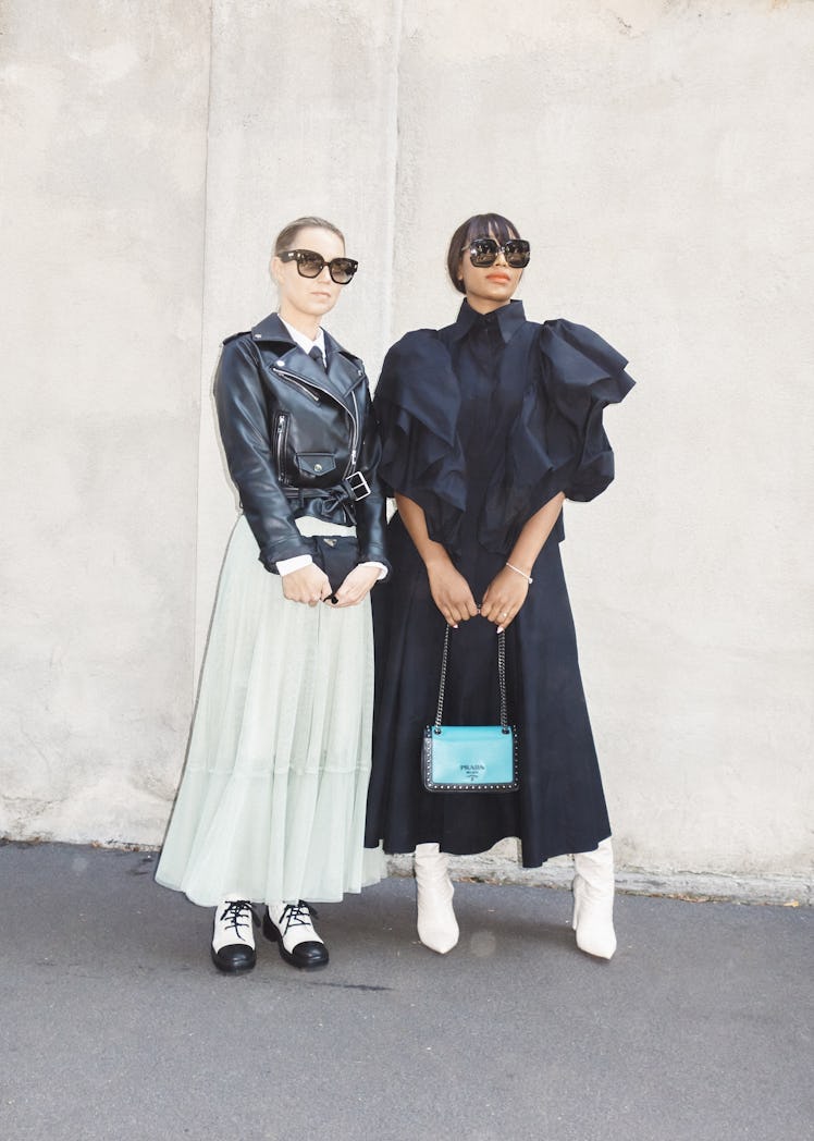 A woman in a black dress and a woman in a black jacket and beige skirt at Milano Fashion Week 2022