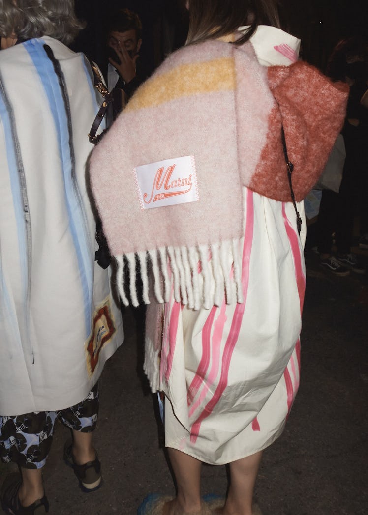 The back of a woman in a white-pink dress and a beige scarf by Marni at the Milan Fashion Week 2022