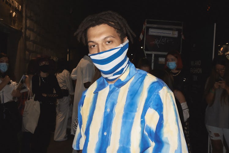 A man in a white-blue striped shirt and mask at the Milan Fashion Week 2022