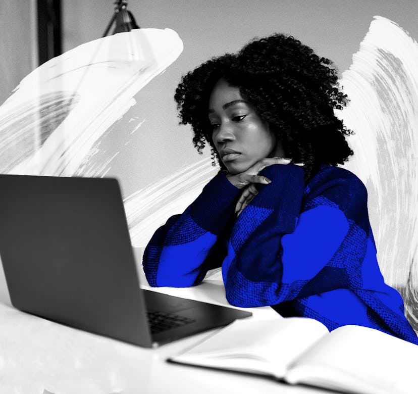A curly woman with a sad look on her face looking at her laptop