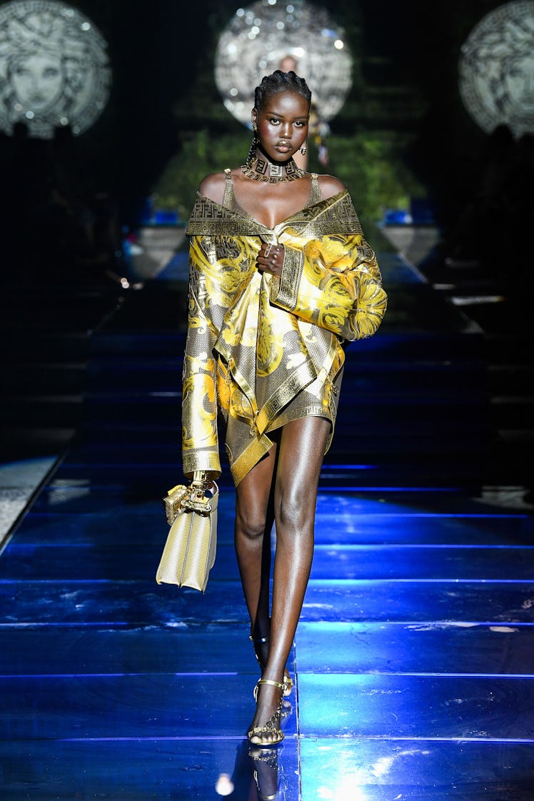 A model walking the runway for Milan Fashion Week Spring 2022 in a Versace by Fendi silk jacket in g...