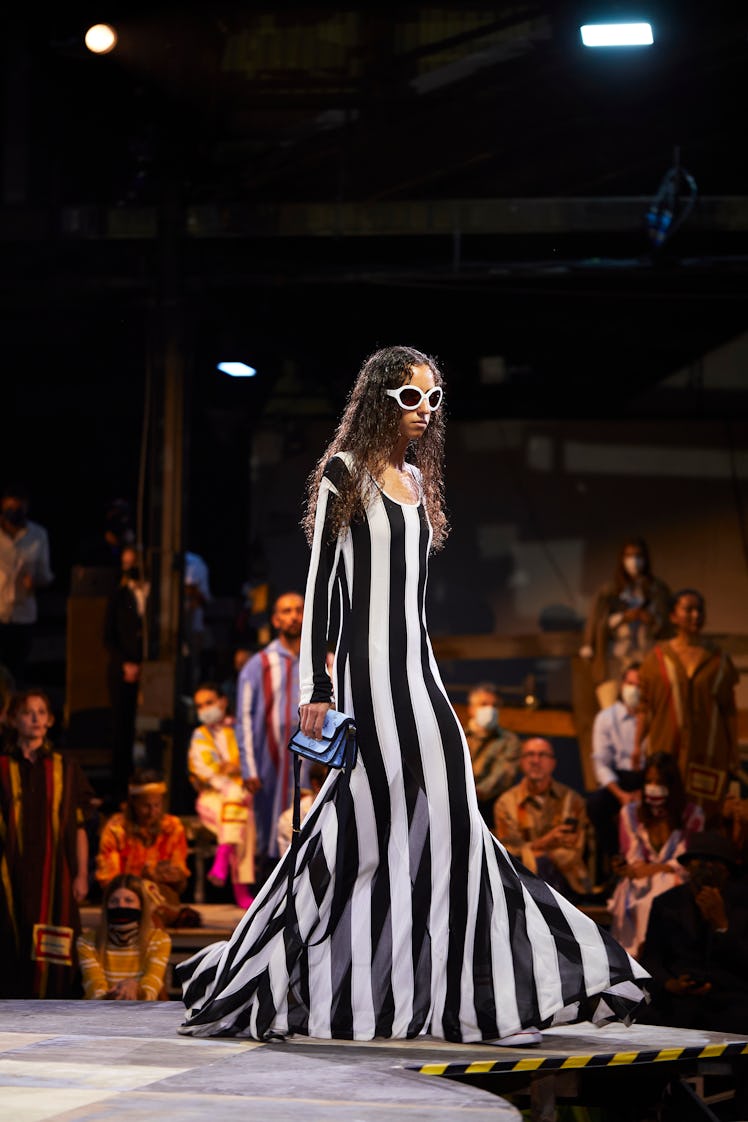 A model walking the runway in a striped maxi dress by Marni during Milan Fashion Week Spring 2022 