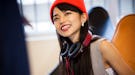 Young woman with headphones around her neck, happy that October 15, 2021 will be the best day of the...