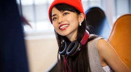 Young woman with headphones around her neck, happy that October 15, 2021 will be the best day of the...