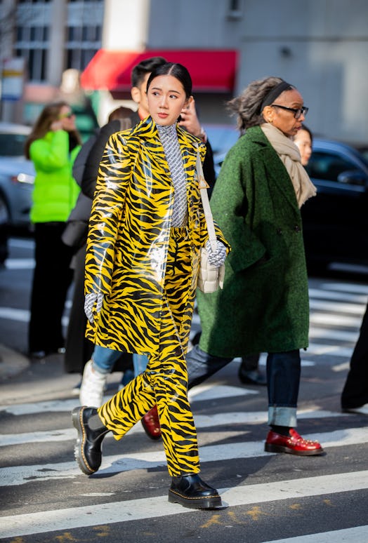 A guest is seen wearing yellow black jacket and pants with zebra print, turtleneck with graphic prin...
