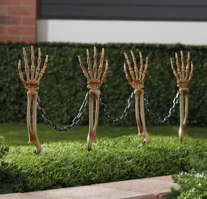 Four skeleton hands/arms coming out of the ground
