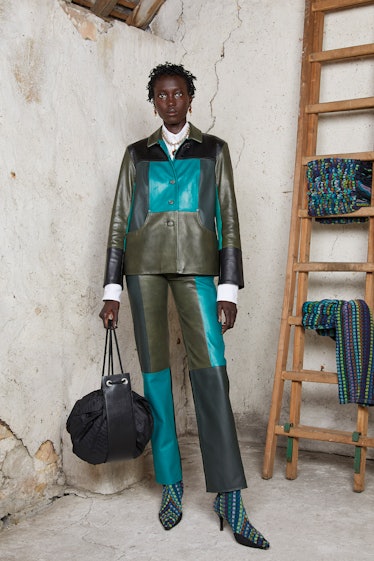 A model wearing a grey-teal patchwork suit by Marine Serre