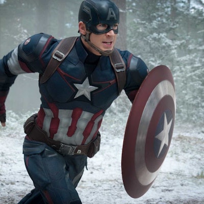 Captain America running through a forest covered in snow 