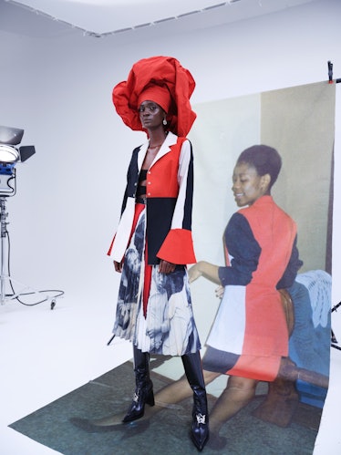 A model posing in a red-white-black-outfit by Thebe Magugu in a studio