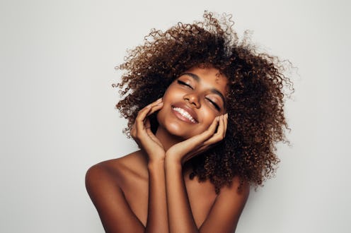 Woman touching skin and smiling