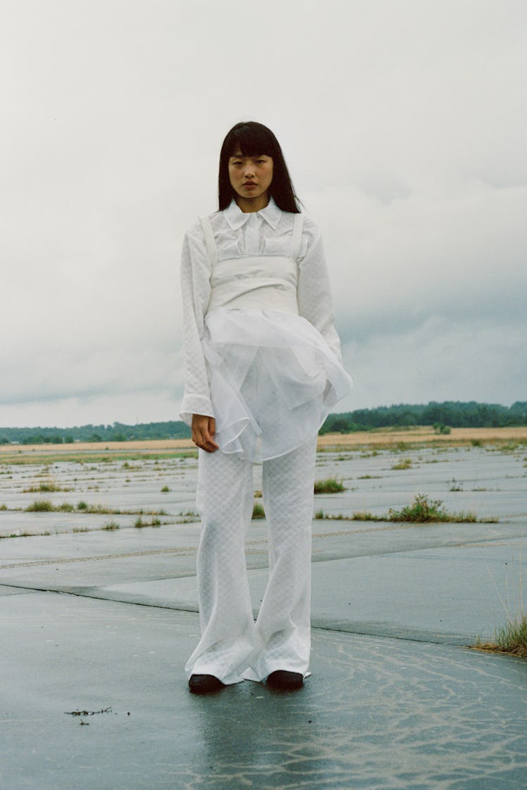 A model posing in a white Cecilie Bahnsen shirt and pants