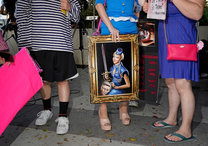 Britney Spears fan holding Britney Spears artwork depicting her holding her father's severed head