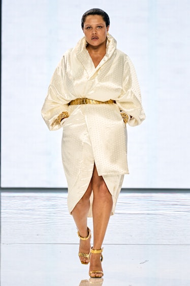 A model walking on a runway in a beige satin dress by Balmain