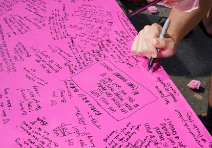 A fan writing a support message to Britney Spears on a pink banner