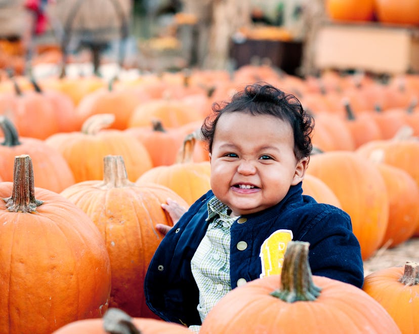 Baby sitting in a pumpkin patch 